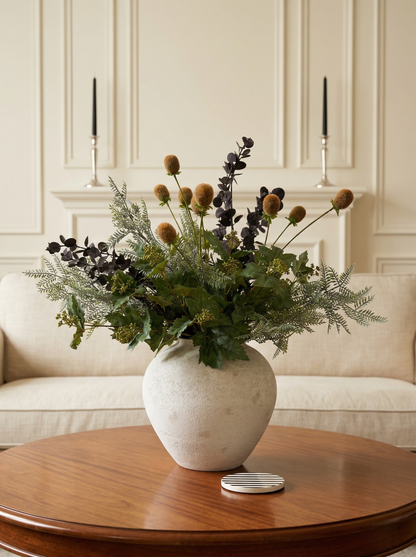 Decorative flower arrangement in a white vase on a wooden table with a neutral background