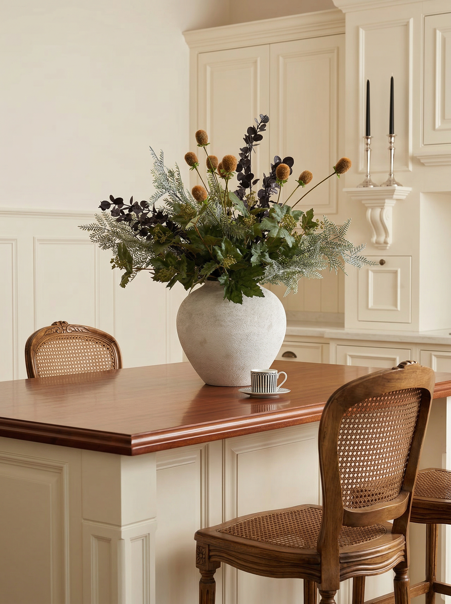 Dining area with a wooden table, white vase with flowers, and wicker chairs