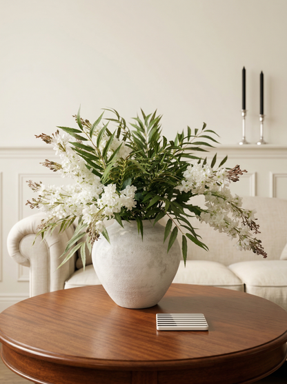 Floral arrangement in a vase on a wooden table with a neutral background