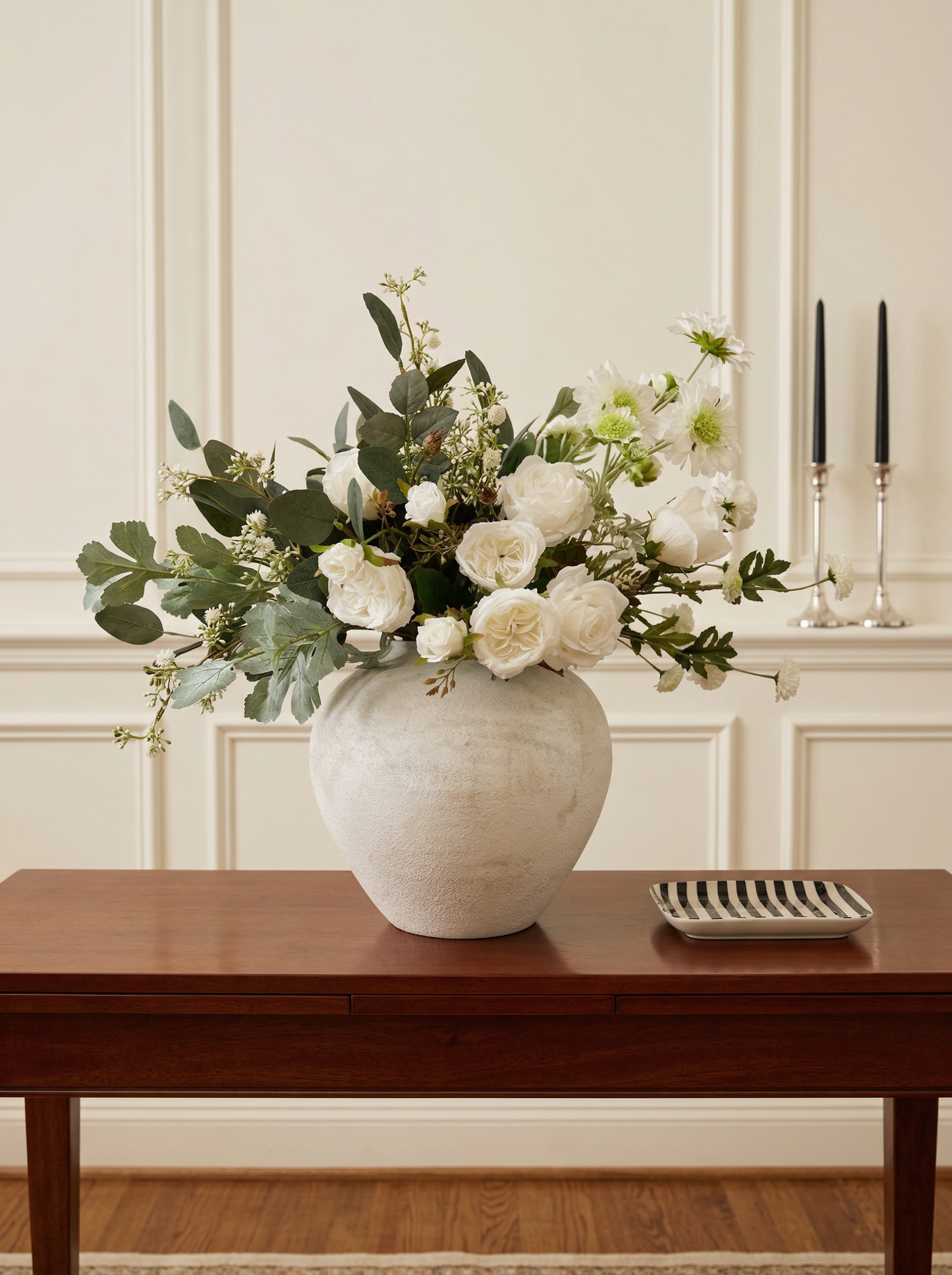 Floral arrangement in a white vase on a wooden table with a neutral wall background