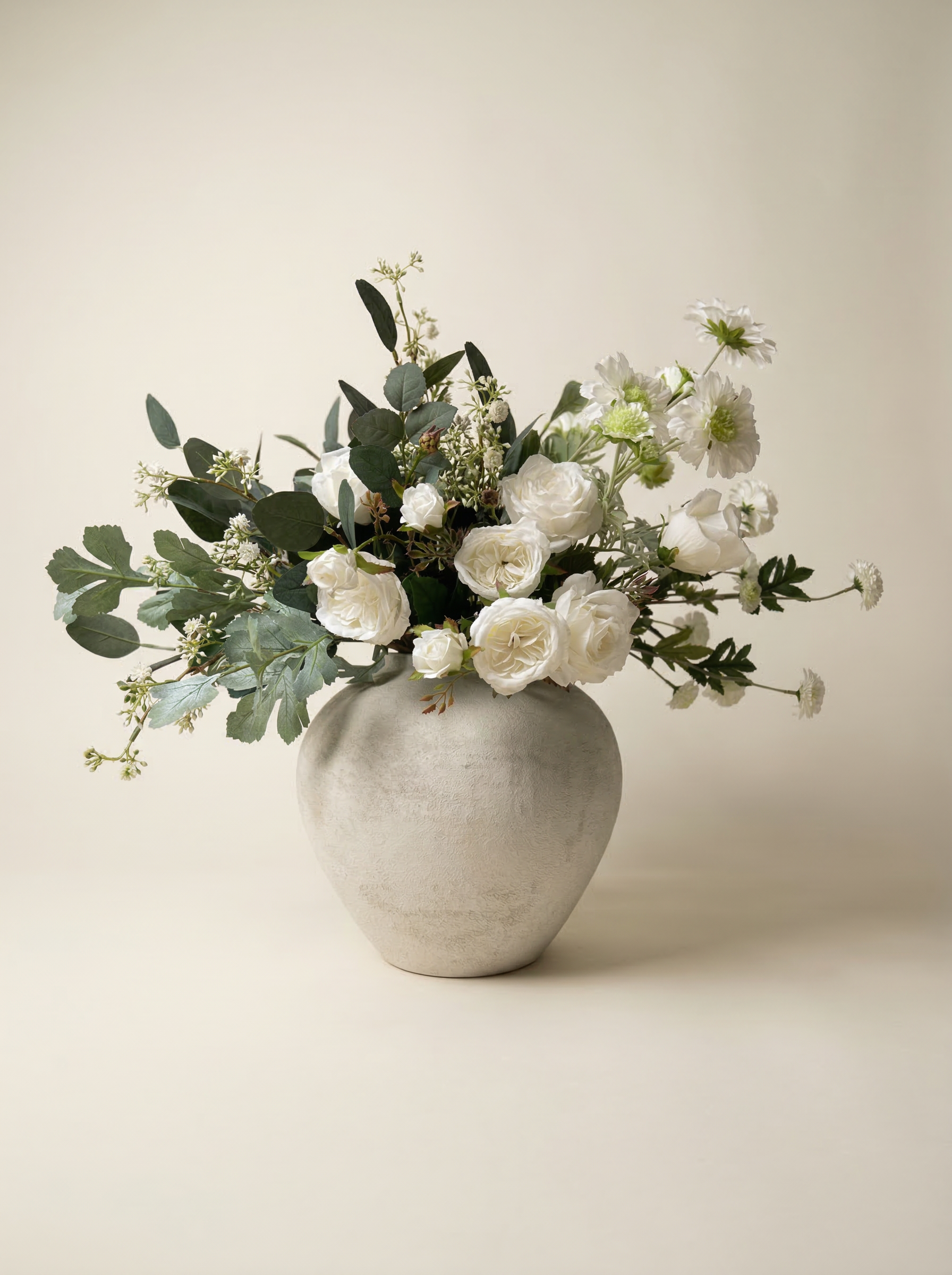 Floral arrangement in a gray vase on a beige background
