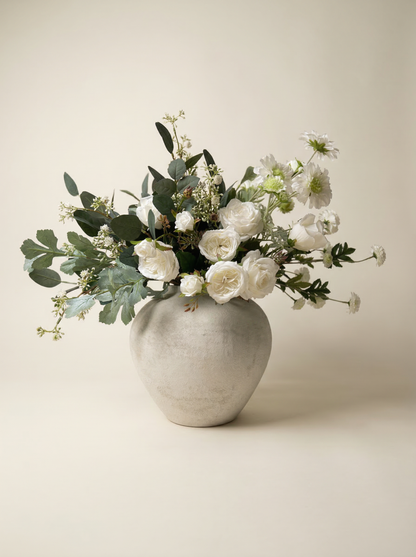 Floral arrangement in a gray vase on a beige background