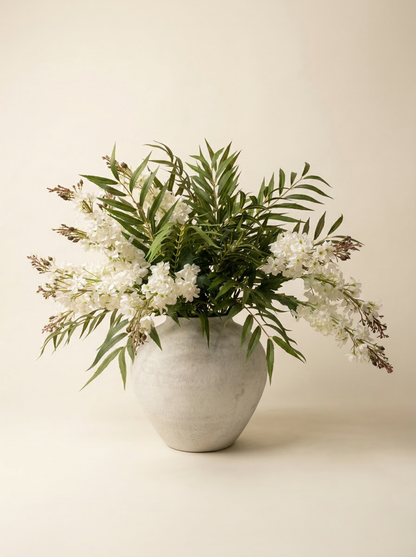 Floral arrangement in a white vase on a beige background