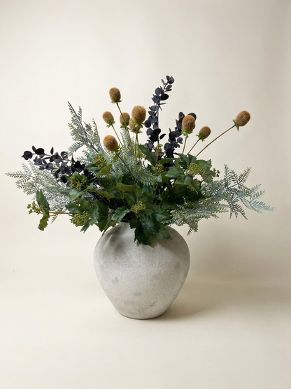 Bouquet of flowers in a concrete vase on a light background